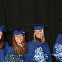 four friends using pom poms at the photobooth